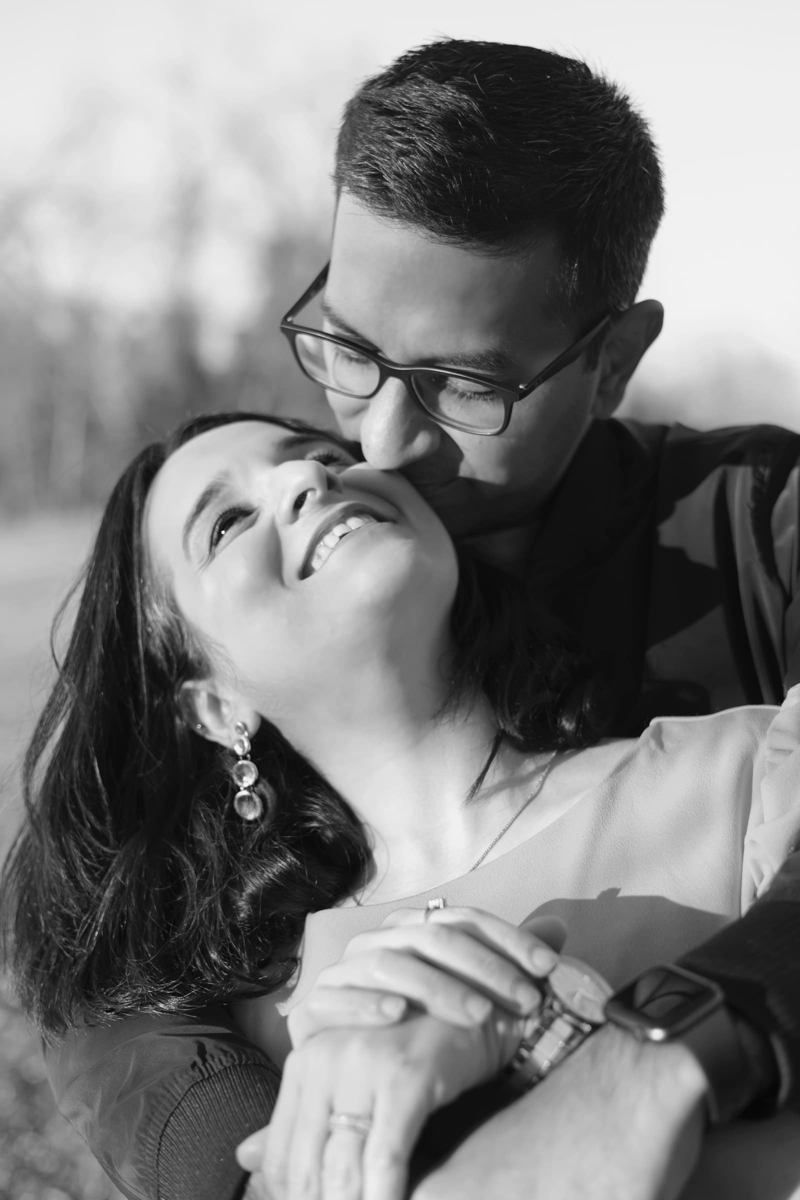 Black-and-white close-up of a couple, foreheads together, sharing a tender smile.